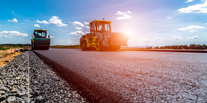 Photo of two tractors laying a road