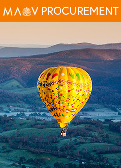 A hot air balloon floating over a lush green mountainous landscape